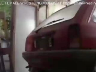 Två flickor slagsmål i en bil junkyard